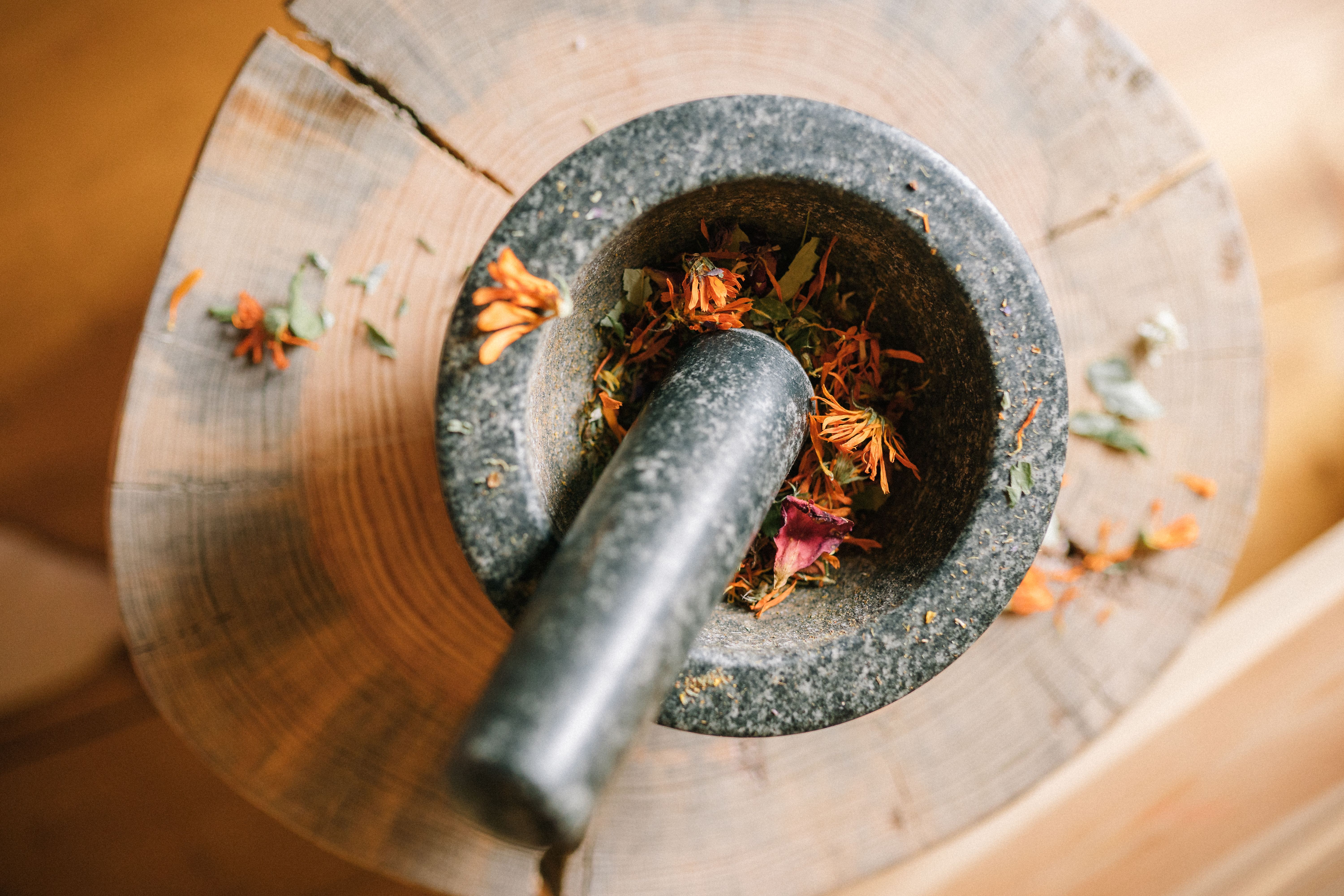 Traditional herbs being prepared in a stone mortar